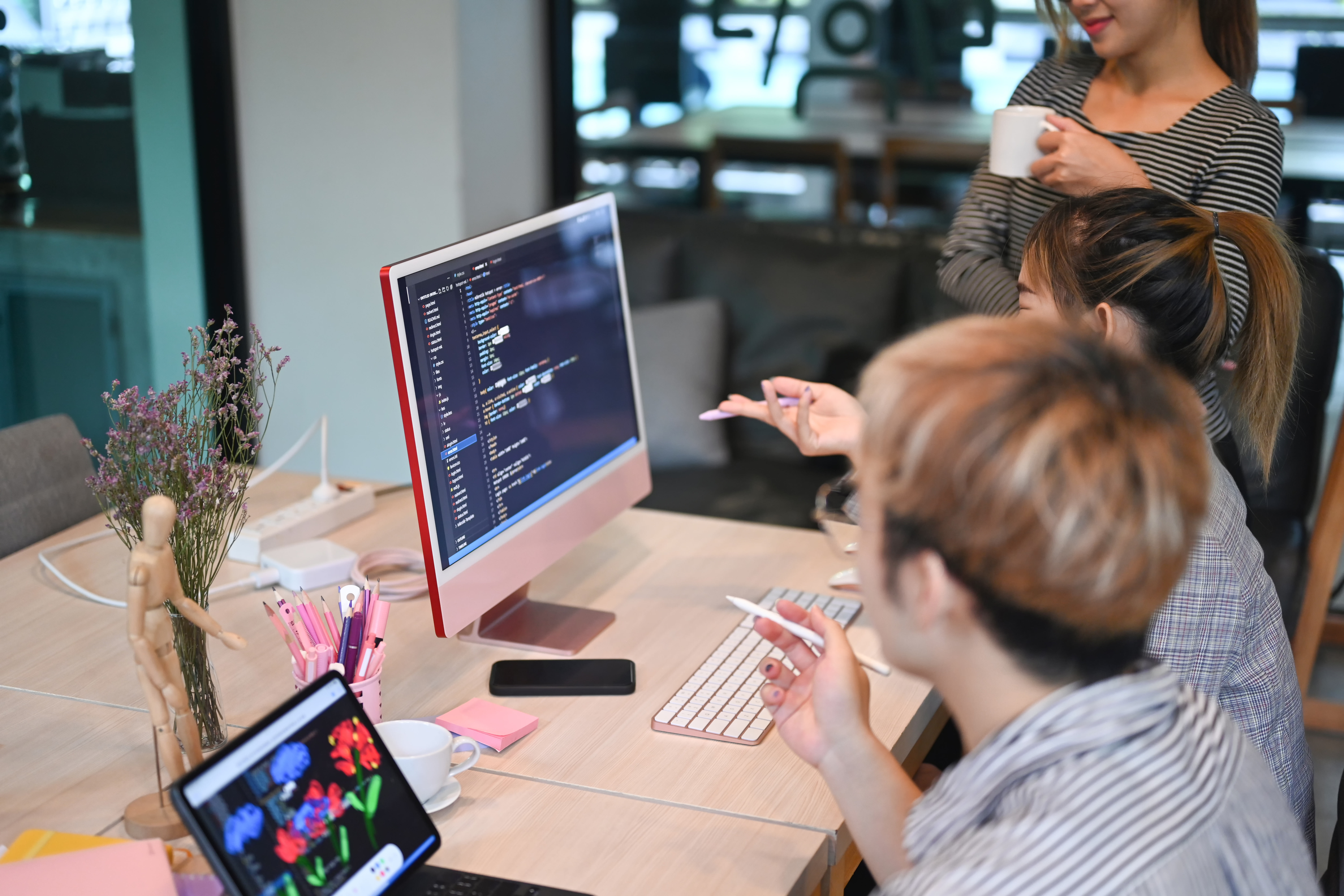 The cover image for the content on "The Ultimate Guide to Developer Platforms for Directors of Engineering' features a team of young software developers working together to design and code websites