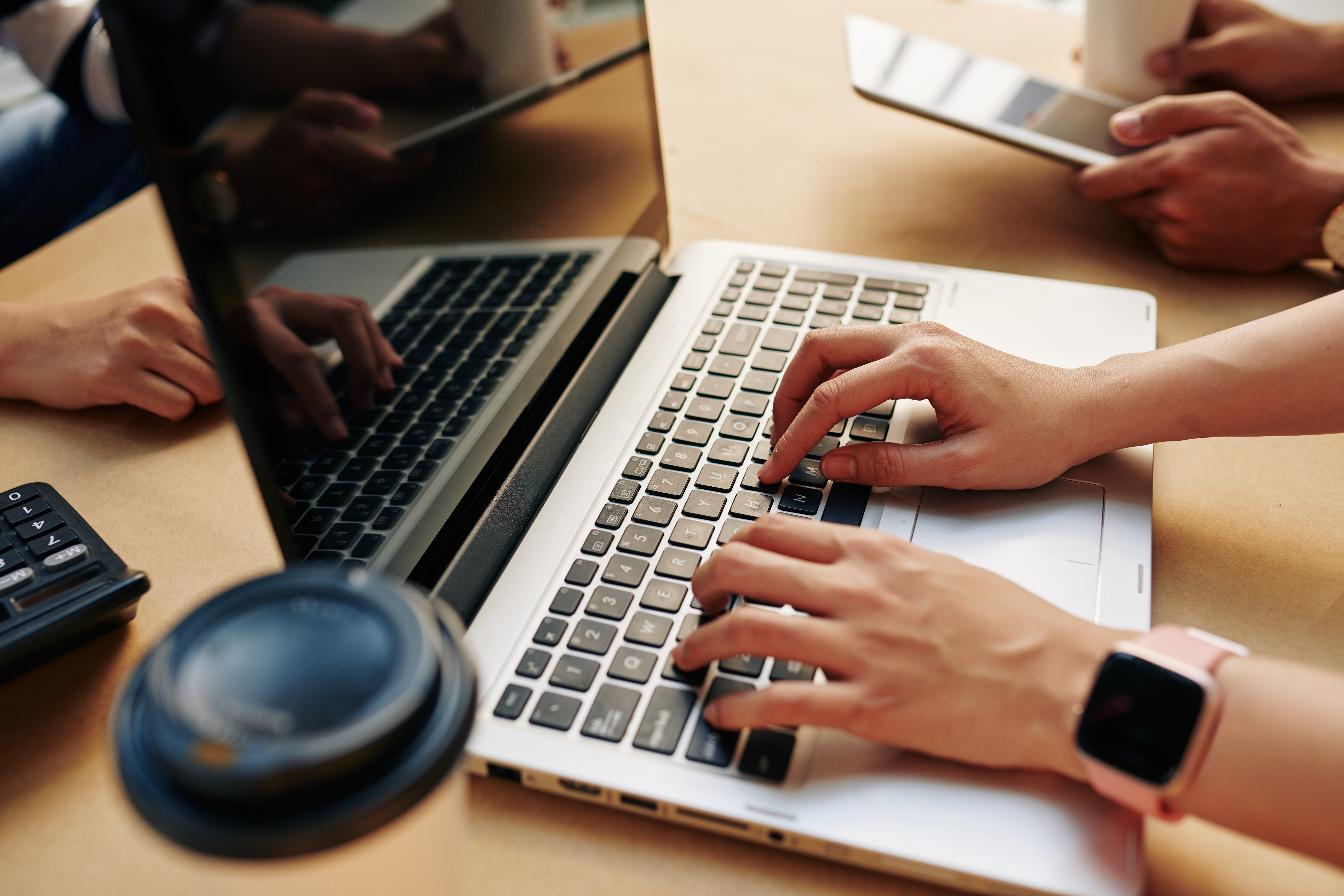 Cover image for the content on Platform Engineering, featuring a programming developer sitting at a desk with their hands on the laptop. On the table, there is a cup of coffee.