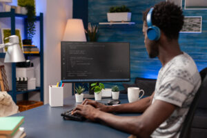 Cover to the article "AI for Coding: Enterprise Developer Platforms and the Coding Revolution". In the picture, an African American coder employee is programming business code.