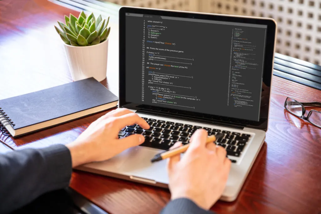 Cover of the article “Boosting dev productivity: How to write complete unit tests faster with a contextualized AI tool”. A white person stands in front of a laptop with their hands under the keyboard. Codes are on the laptop screen.