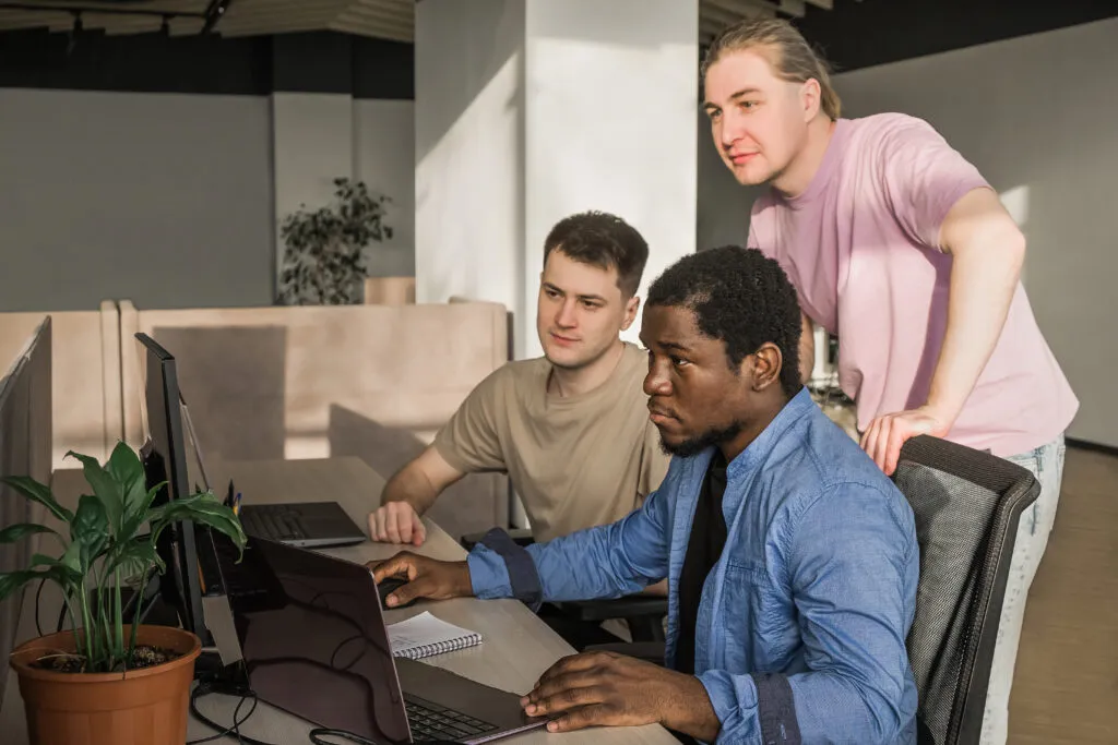 Cover image for the content on SRE Practices. In the content, there are three developers in a room facing the computer.