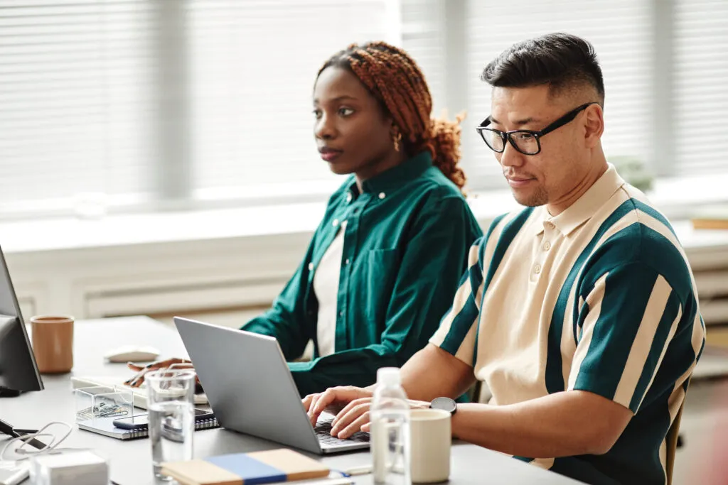 Cover image of the content about Software Development teams, where there are two people working together in an office.