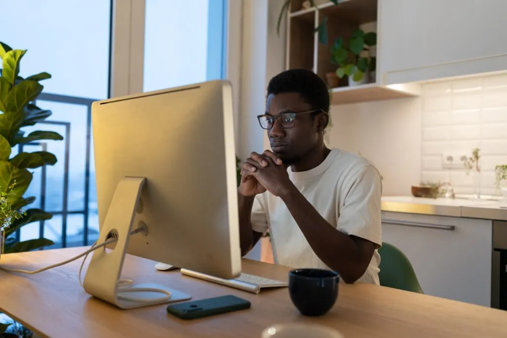 Cover image of the content about Platform Engineering vs DevOps, showing a focused software developer working on coding an application from home, with the computer screen in focus.